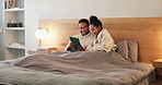 Couple, talk or relax in hotel room with tablet, check website booking and romantic vacation at night. Late, happy married people and rest in accommodation bed with tech, chat and bonding on holiday.