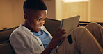 Happy, online and child with tablet at night, home and watch movie on web in lounge or entertainment. Streaming, film and black kid with tech in evening, relax and smile with subscription in house