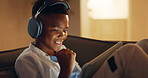 Tablet, fist pump and happy child in home with headphones, score points and online entertainment. Tech, audio and African boy in living room for gaming success, yes or victory achievement at night