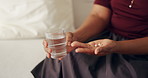 Water, pills and hands of person in home for medical treatment, prescription and tablets for recovery. Healthcare, woman and medication in living room for vitamins, supplements and drugs on sofa