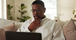 Man, thinking and remote work on sofa with laptop, financial planning and check website for tax return. Black person, glasses and freelancer in home with computer, problem solving and finance review.