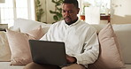 Laptop, typing and black man on sofa with remote work, check timesheet or report for HR administration. Human resources worker, person and review payroll in home with computer, website and planning.