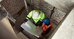 Above, blueprint and construction workers on site for discussion on building, renovation or repairs. Conversation, men and civil engineers with floor plan for maintenance on industrial project.