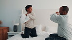 Bonding, game and pillow fighting son with dad in home bedroom for morning or playful activity. African family, love and parent playing with boy child on bed in apartment for fun relationship
