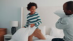 Game, love and pillow fighting son with dad in home bedroom for morning or playful activity. African family, bonding and parent playing with boy child on bed in apartment for fun relationship