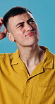 Confused, man and thinking in studio, doubt and plan for decision with frown or uncertain expression. Blue background, unsure and person with questions, reflection and contemplating choice and ideas