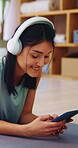 Fitness, music and phone with happy woman on floor in home to download yoga tutorial. App, headphones and text message with person in apartment for health activity, online subscription or wellness