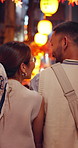 Walking, night market and back of couple in city on holiday, getaway or weekend trip with exploring. Adventure, cultural festival and Asian person at traditional bazaar for sightseeing on vacation.