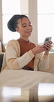 Texting, smile and woman on sofa with phone, internet search and communication on online platform. Happy, digital and person in house with tech, social media update and chatting on virtual app.