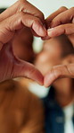 Couple, kiss and heart hands in home with romantic relationship, loyalty and support for wellness. Married, people and affection in apartment with love sign, connection and care for bonding together.