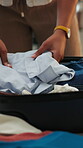Hands, packing and suitcase with person in home bedroom for holiday or travel preparation. Bag, getting ready and organize clothes with tourist closeup in apartment for getaway, trip of vacation