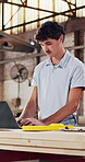 Carpentry, laptop and typing with man in workshop for manufacturing or production checklist. Computer, feedback and planning with person in woodworking factory for online order or quality control