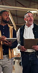 Men, tablet and talking in workshop for carpentry, project planning and inventory management. Team, clipboard and technology in woodworking factory for compliance guidelines, advice or upgrade ideas