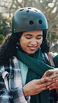 Woman, phone and typing outdoor with helmet on commute, travel and social media post at park. Happy, technology and search on internet for student portral, communication or download app with smile