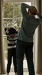 Window, stretching and back of dad with child in home to start day, morning routine and sunlight. Family, open and father with boy for view, sunshine and curtains for fresh air, wellness and bonding