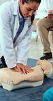 Doctor, demonstration and dummy for cpr training at hospital for workshop, chest or protocol. Woman, healthcare team and emergency procedure for first aid, breathing and demo or teaching compression