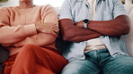 Divorce, sofa and couple with crossed arms for fight, conflict and tension for argument in home. Hands, marriage and man with woman with disagreement, frustrated and upset for relationship issue