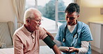 Blood pressure, home and nurse with senior man for healthcare exam, talking or machine. Retirement, female caregiver and old person with patient care, hypertension and vitals for heart wellness