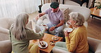 Friends, tea party and senior people in home to relax together, pour drink or share story at reunion. Serving beverage, retirement and group in lounge for socializing, talk and above at house visit
