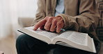 Bible, hands and elderly person in living room for morning prayer, worship study or Christian faith in home. Reading, religion and senior pensioner with holy book, gospel or spiritual guide in house