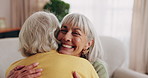 Old woman, relax and friends at house with hug, welcome and bonding together for reunion. Smile, senior people and talking in lounge with embrace, friendly affection and compassion for weekend visit