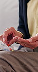 Hands, pill box and sorting with old person in home living room for chronic medication. Organization, tablets and weekly with senior in apartment for healthcare, pharmaceuticals or retirement