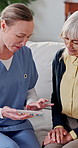 Pills, nurse and old woman in home with medicine, healthcare schedule and explain dose. Caregiver, people and talking in living room with medication box for medical help, support and retirement
