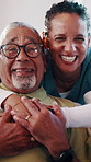 Face, caregiver and old man in retirement home with hug, bonding together and laugh for funny joke. Happy, elderly person and nurse embrace with healthcare assistance, humor and medical support.