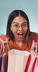 Excited, shopping bags and wow with face of woman in studio for reaction to deal or sale. Energy, glasses and surprise with customer person on gray background for bargain, discount or purchase