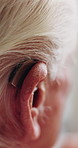 Back, old man and ear in home with hearing aid, auditory support and implant prescription for audio. Closeup, deaf and senior person with disability, cochlear device and medical innovation for sound
