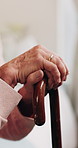 Senior, hands and thinking with cane in home for retirement, past moment or nostalgia in house. Thoughtful, elderly or male person with walking stick for support, reflection or memory in old age home