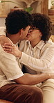 Kiss, couple and happy on home sofa with love, connection and support or care in healthy relationship. Man, woman or people with glasses on lounge couch with hug, security and safety in house