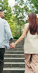 Couple, running and holding hands on stairs in park for outdoor travel, fun bonding or tourism. Back view, man and woman on staircase for weekend, holiday or romantic adventure in nature together