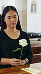 Thinking, sad and woman at coffin with rose, remember and grieving past with mourning. Reflection, coping and person in church with flower, bereavement and emotional flashback at memorial service.