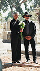 Senior, couple and flowers at funeral in graveyard for grief, mourning death and final goodbye. Pensioner, people and floral bouquet at burial service for support, bereavement and respect in cemetery