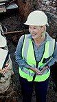 Team, woman and happy contractor at construction site, development preparation or laughing. Collaboration, engineer or mature person with progress update, funny joke or excavation feedback from above