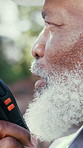 Construction, talk or black man outdoor with radio, task brief or inspection update in chat. Bokeh, closeup or mature engineer with tech, progress feedback or project coordination in communication.