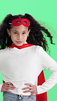 Face, child and superhero in studio with confidence, smile and pretend with wind on green background. Portrait, cape and happy girl with costume, fantasy cosplay or fearless kid with role play
