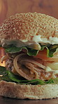 Flame, grill and hamburger in kitchen with fast food, cuisine serving or catering for lunch dish. Fire, beef and bun in restaurant with seeds, vegetable ingredients and hospitality for takeaway meal