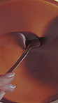 Baking, hands and chocolate mixture on closeup for mousse dessert, gourmet treat or creamy recipe. Above, woman and ganache sauce for cake filling, homemade pudding or ingredients preparation in home