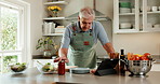Cooking, online and senior man with tablet in kitchen, listen and watching tutorial on social media. Meal prep, tips and old person with ingredients for lunch, recipe and research with tech in house