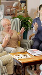 Retirement, nurse or old people with wrist exercise, hand mobility or healthy aging in lounge. Happy, senior group or caregiver with joint movement, rehabilitation or arthritis care in nursing home.