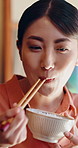 Smile, Asian woman and eating at house with chopsticks, healthy rice and traditional food for lunch. Female person, bowl and utensils in home for brunch, nutrition meal and authentic Chinese cuisine 