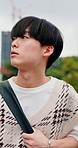 Thinking, Asian man and student in city for travel, vision and daydreaming for learning abroad. Thoughts, male person and walking in town for morning commute, reflection and scholarship for education