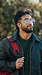 Walking, nature and man with backpack at university for studying, education or learning. Happy, thinking and student outdoor on college campus with planning, ideas or decision on scholarship.