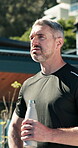 Fitness, outdoor and mature man drinking water on break, rest and exhausted after intense workout. Male person, tired athlete and pause to hydrate for wellness, health and training exercise in summer