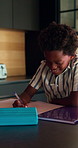 Learning, writing or happy child with book in home for mathematics, education or assessment. Boy, kid or smile with notebook, numbers or equations for problem solving, homework or assignment in house