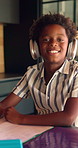 Headphones, face and child in kitchen for homework with listening to music at house with notebook. Happy, student and portrait of boy study for mathematics quiz for development, growth or education.
