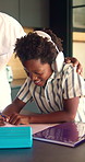 Headphones, father and child in kitchen for homework with listening to music at house with help. Dad, student and boy kid studying for mathematics quiz in book for development, growth or education.