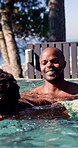 Swimming, pool and dad with boy for learning, aquatic skills and playful development or exercise. Black family, help and father with child for water sports, health and wellness together outdoors